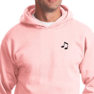 May include: A pink hooded sweatshirt with a small black musical note graphic on the front.