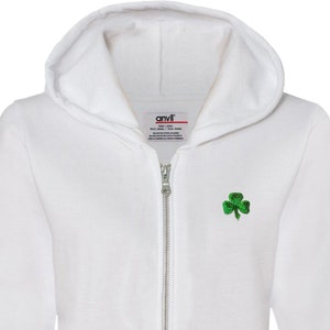 May include: White zippered hoodie with a green shamrock embroidered on the left chest. The hoodie has a drawstring hood and two front pockets.