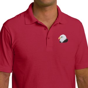 Könnte beinhalten: Ein rotes Poloshirt mit einem gestickten Weißkopfseeadler auf der linken Brust.