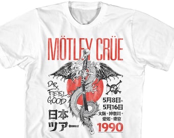 Può includere: Maglietta bianca con una grafica nera e rossa di un drago che tiene una spada. Il testo "Motley Crue" è stampato in rosso nella parte superiore della grafica. Il testo "Dr Feel Good" è stampato in nero sul lato sinistro della grafica. Il testo "日本ツアー 1990" è stampato in nero nella parte inferiore della grafica.