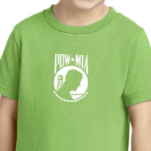 May include: A lime green youth t-shirt with a white POW MIA logo. The logo features a silhouette of a person's head with a barbed wire fence and a guard tower.
