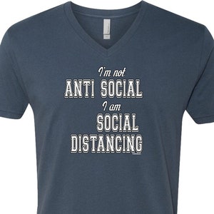May include: A dark blue v-neck t-shirt with the text "I'm not anti social I am social distancing" in white.