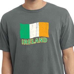 May include: A charcoal grey t-shirt with a distressed Irish flag graphic and the word "IRELAND" printed below it.