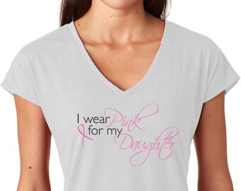 Puede incluir: Una camiseta blanca de cuello en V con una cinta rosa y el texto "I wear Pink for my Daughter".