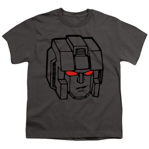 May include: A dark gray t-shirt with a black and white illustration of a robot head with red eyes. The robot has a square head with a rectangular visor and a square jaw.