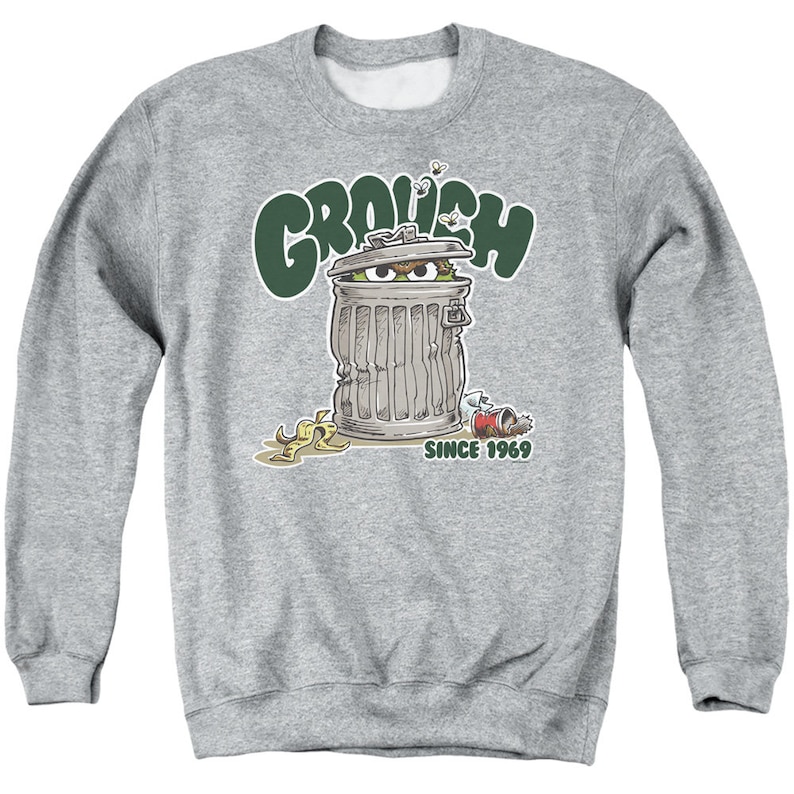 May include: A gray sweatshirt with a green "Grouchy" graphic. The graphic features a green monster peeking out of a trash can with the text "Since 1969".