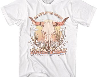 May include: White t-shirt with a vintage-style graphic of a skull with horns, surrounded by cacti and the text "On the Road Again Willie Nelson".