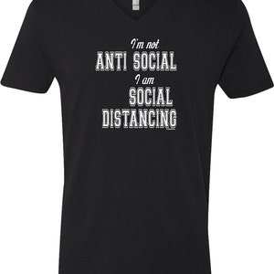 May include: Black V-neck t-shirt with white text that reads "I'm not anti social I am social distancing".