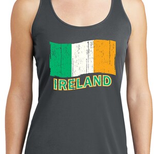 May include: A dark gray tank top with a distressed Irish flag graphic and the word "IRELAND" printed in orange. The model is wearing black leggings.