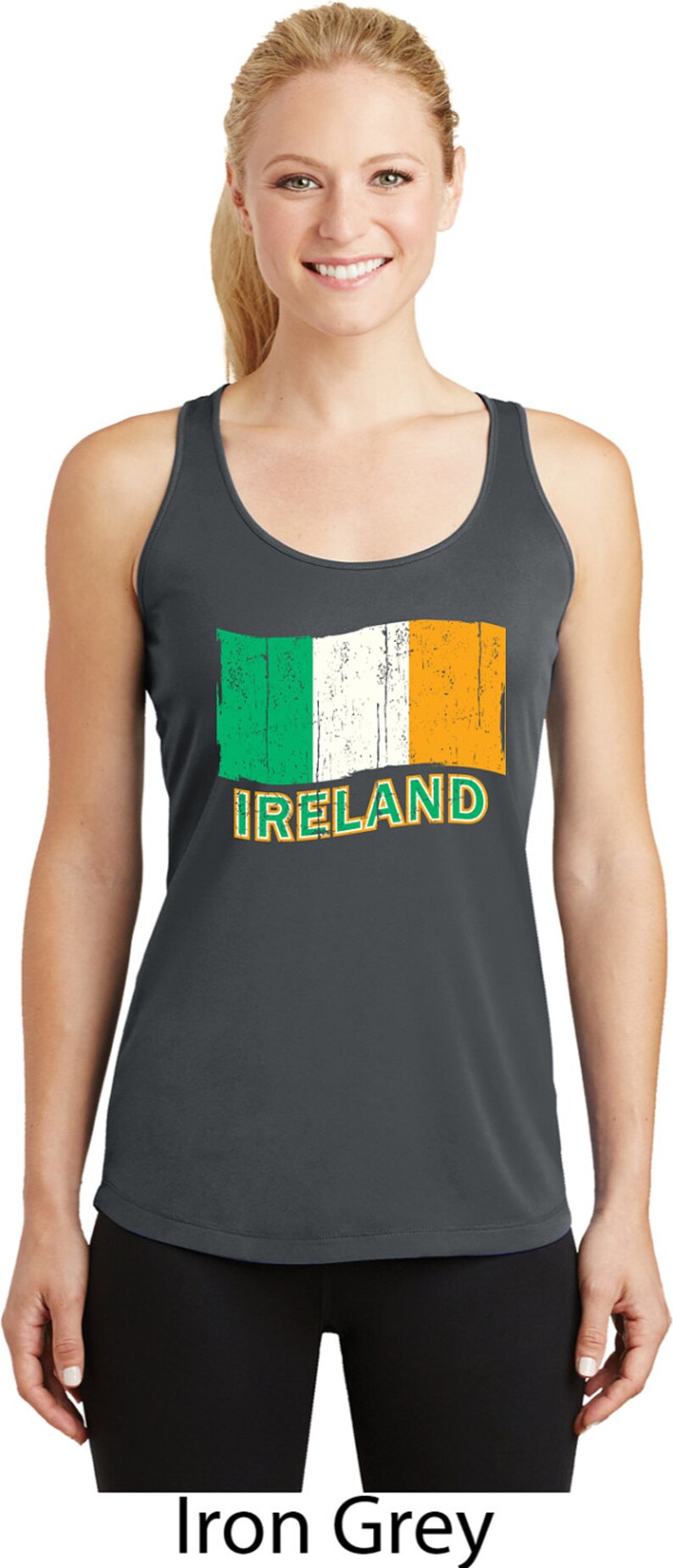 May include: A dark gray tank top with a distressed Irish flag graphic and the word "IRELAND" printed in orange. The model is wearing black leggings.