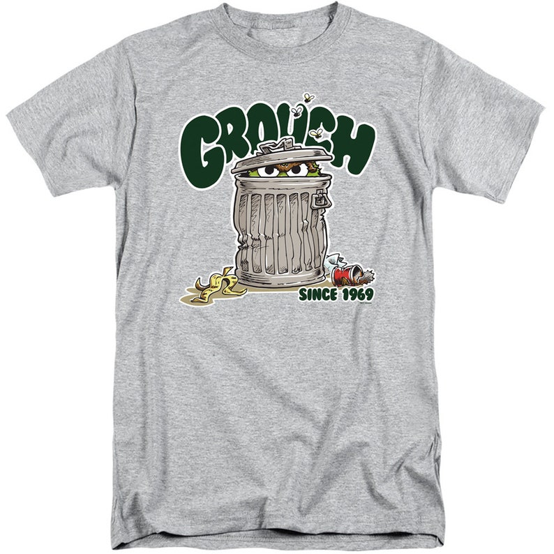 May include: A gray t-shirt with a green and white illustration of Oscar the Grouch from Sesame Street. Oscar is peeking out of a trash can with the text "Grouch" above him and "Since 1969" below him.