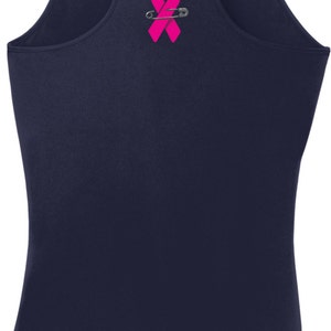 May include: A navy blue tank top with a pink ribbon and safety pin graphic.