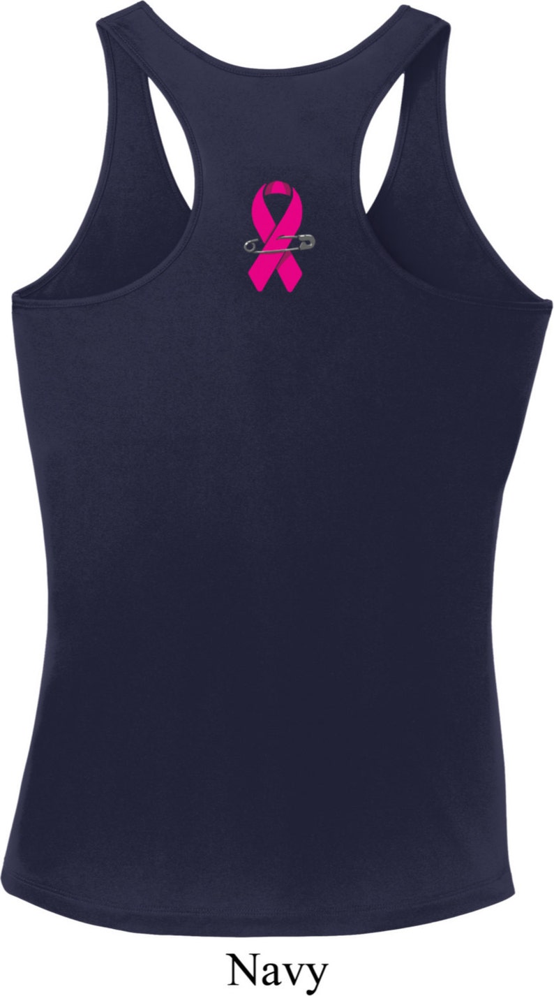 May include: A navy blue tank top with a pink ribbon and safety pin graphic.