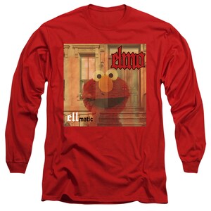 Puede incluir: Camiseta roja de manga larga con un gr&aacute;fico de Elmo de Plaza S&eacute;samo. El gr&aacute;fico es una portada de &aacute;lbum vintage con el texto "Elmo" y "ellmatic" en &eacute;l.