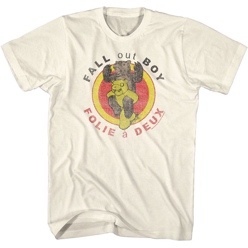 May include: A white t-shirt with a vintage-style graphic of two bears in a circle. The text "Fall Out Boy" is above the bears and "Folie &agrave; Deux" is below.