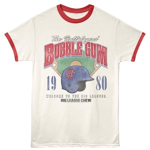 May include: Cream-colored baseball t-shirt with red trim. The front features a baseball helmet graphic and the words "BUBBLE GUM" in red, along with "1980" and "WELCOME TO THE BIG LEAGUES. BIG LEAGUE CHEW."