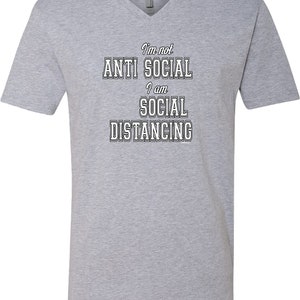 May include: Gray V-neck t-shirt with the text "I'm not anti social I am social distancing" in black.
