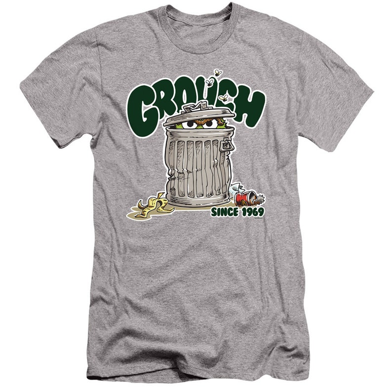 May include: A grey t-shirt with a green cartoon character peeking out of a trash can. The text "GROUCH SINCE 1969" is printed on the shirt.