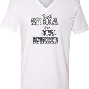 May include: White V-neck t-shirt with the text "I'm not anti social I am social distancing" in black.