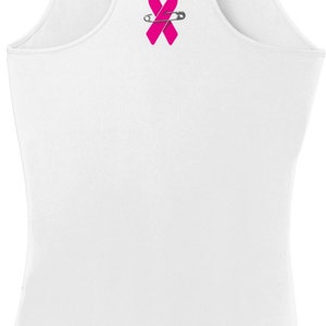 May include: White tank top with a pink ribbon and a safety pin on the back.