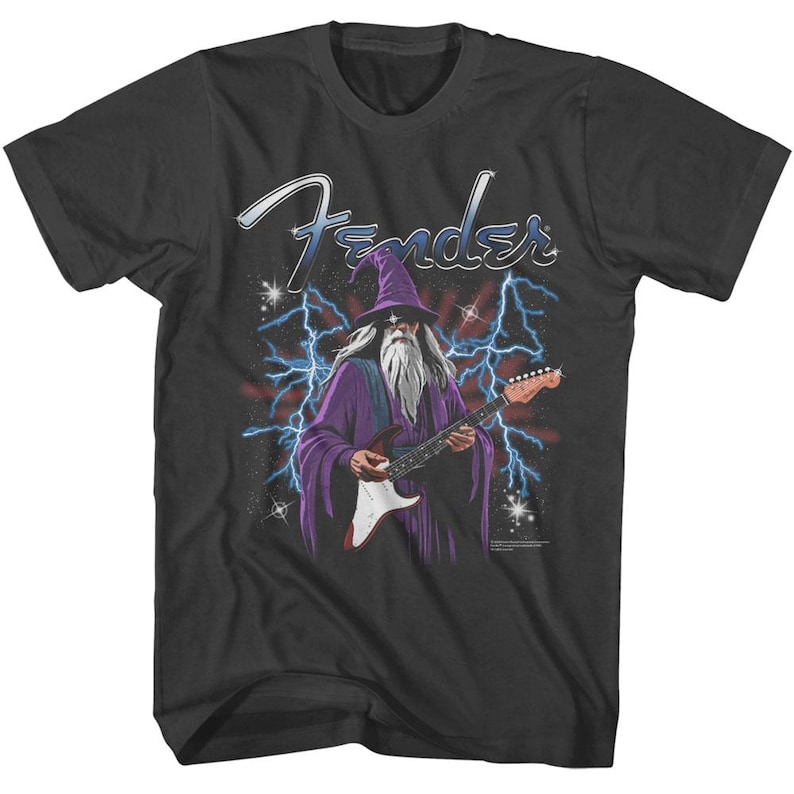 May include: Black t-shirt with a graphic of a wizard playing a Fender electric guitar. The wizard is wearing a purple robe and a pointed hat. The text "Fender" is above the wizard.