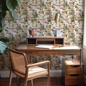 May include: A home office featuring a wooden desk and chair, a lamp, and a filing cabinet. The wall is adorned with wallpaper featuring a mushroom and floral design.