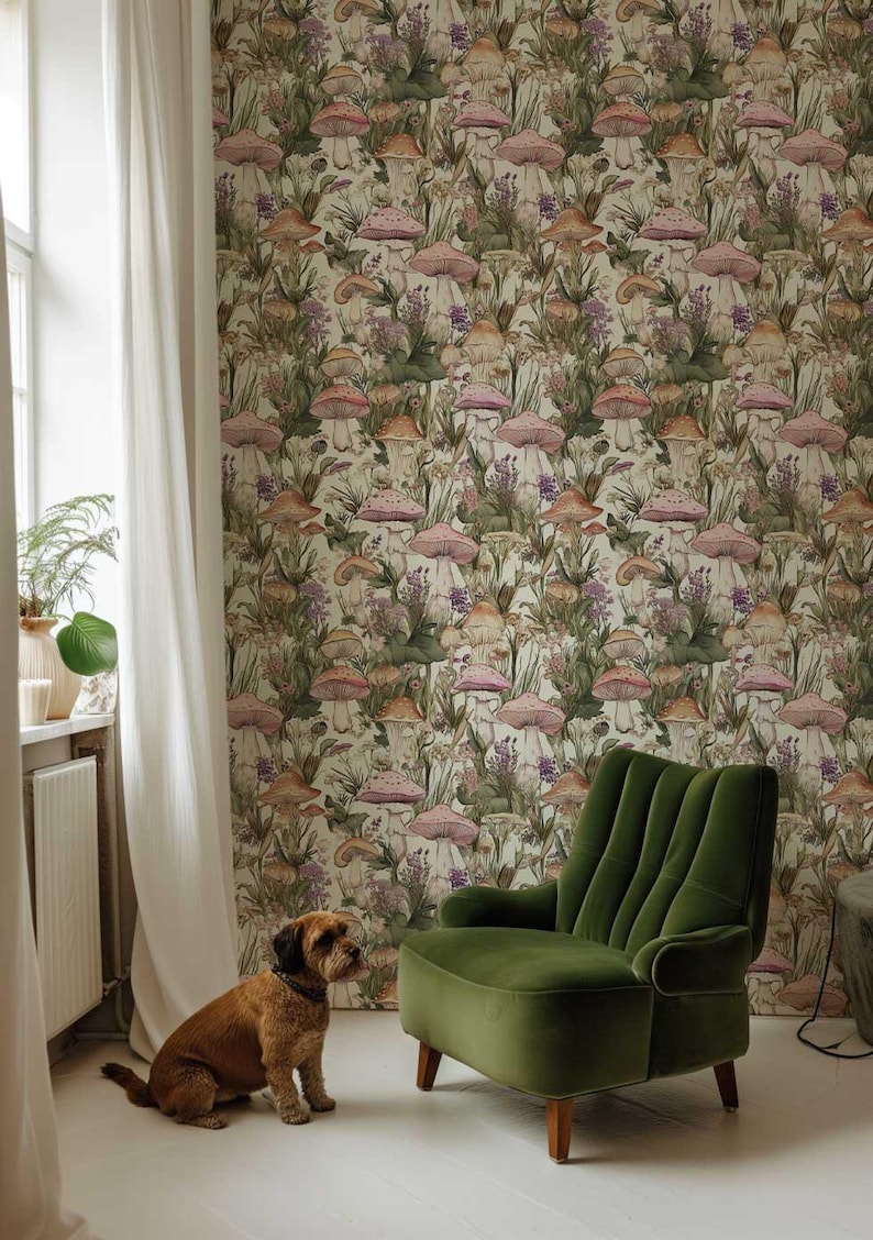 May include: A green velvet armchair sits in a room with white walls and a mushroom-themed wallpaper. A brown dog sits on the floor in front of the chair.