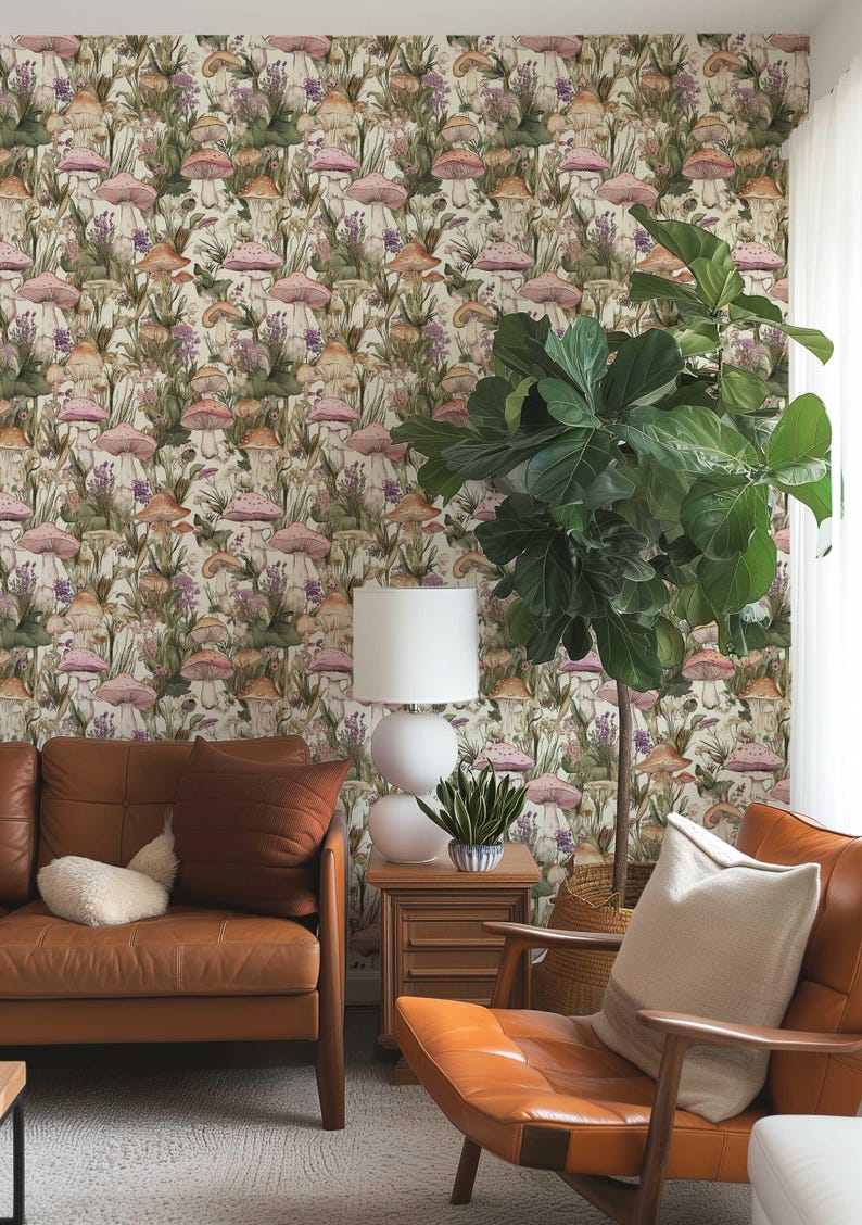 May include: A living room interior featuring a brown leather sofa and armchair, a white lamp, and a large potted plant. The wall is adorned with wallpaper featuring a repeating pattern of pink and brown mushrooms and green foliage.