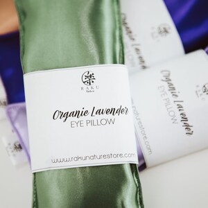 Puede incluir: Almohadas para ojos de sat&eacute;n verde, morado y marr&oacute;n con etiquetas blancas. La etiqueta de la almohada para ojos verde dice "Organic Lavender Eye Pillow" y "www.rakunaturestore.com".