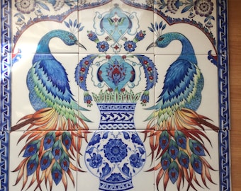 May include: A set of nine ceramic tiles with a peacock design. Two blue peacocks face each other, framing a vase filled with flowers. The tiles have a white background with blue and red details, and a decorative blue border.