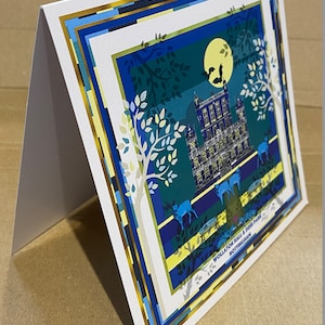 May include: A blue and green card with a gold border. The card features a nighttime illustration of Wollaton Hall & Deer Park, Nottingham. The illustration includes a moon, bats, trees, and deer.