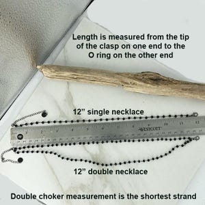 May include: Two black beaded necklaces with metal clasps and O-rings, displayed alongside a Westcott ruler. The top necklace is labeled as a 12-inch single necklace, and the bottom is a 12-inch double necklace. Text indicates length is measured from clasp to O-ring.