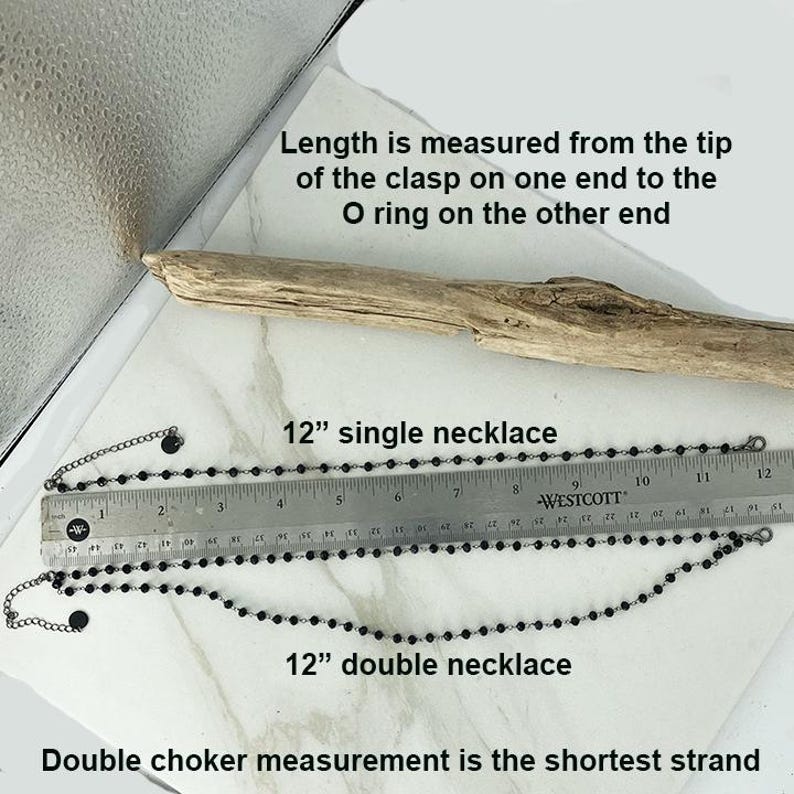 May include: Two black beaded necklaces with metal clasps and O-rings, displayed alongside a Westcott ruler. The top necklace is labeled as a 12-inch single necklace, and the bottom is a 12-inch double necklace. Text indicates length is measured from clasp to O-ring.