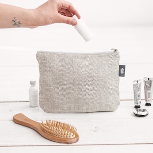 Mittelgroße weiße Kosmetiktasche aus Leinen für die Reise. Vegane Kosmetiktasche für Frauen und Männer. Waschbare umweltfreundliche Kulturtasche mit Reißverschluss
