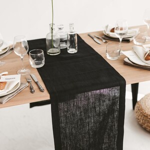 Handmade black linen table runner crafted from natural OEKO-TEX certified fabric. Ideal for cozy, stylish settings during holiday dinners, weddings, or seasonal celebrations. A unique and eco-friendly housewarming gift that adds warmth, texture, and modern elegance to any festive or everyday table.