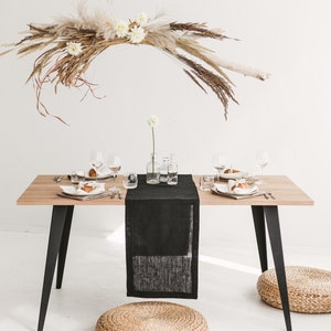 Handmade black linen table runner crafted from natural OEKO-TEX certified fabric. Ideal for cozy, stylish settings during holiday dinners, weddings, or seasonal celebrations. A unique and eco-friendly housewarming gift that adds warmth, texture, and modern elegance to any festive or everyday table.
