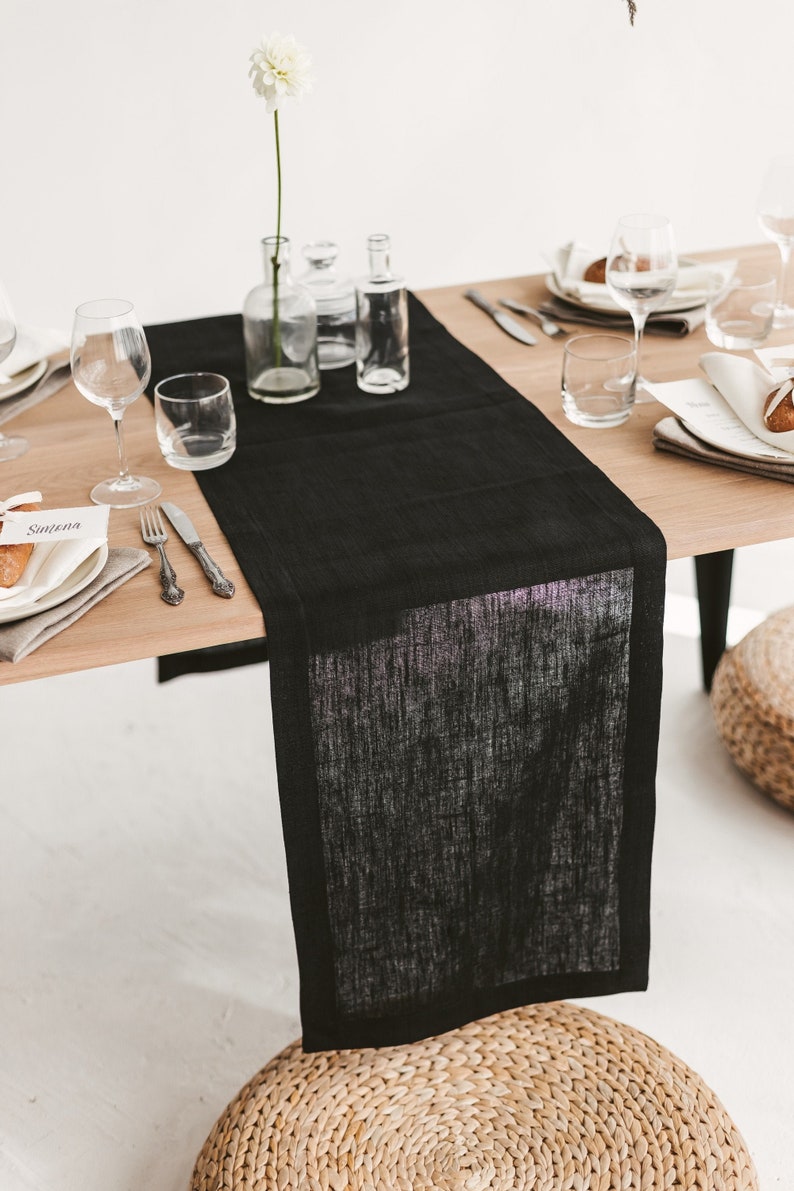 Handmade black linen table runner crafted from natural OEKO-TEX certified fabric. Ideal for cozy, stylish settings during holiday dinners, weddings, or seasonal celebrations. A unique and eco-friendly housewarming gift that adds warmth, texture, and modern elegance to any festive or everyday table.