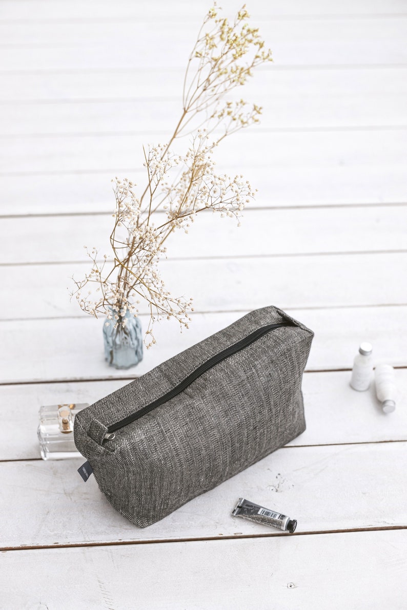 Black linen makeup bag in a herringbone pattern with a black zipper