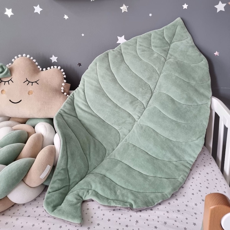 Pu&ograve; includere: Un grande tappetino da gioco a forma di foglia verde con una texture trapuntata. Il tappetino &egrave; realizzato in tessuto morbido e peluche, perfetto per neonati e bambini piccoli.