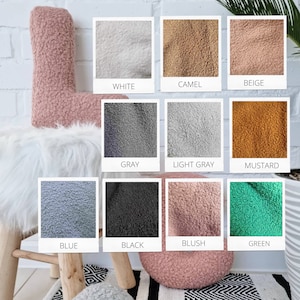 May include: A collection of 10 fabric swatches in various colors, including white, camel, beige, gray, light gray, mustard, blue, black, blush, and green. The swatches are arranged in a grid pattern and are all made of a soft, fluffy material.