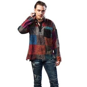 Könnte beinhalten: Ein Mann trägt ein mehrfarbiges Patchwork-Hemd mit langen Ärmeln und eine dunkelblaue Jeans mit Destroyed-Details. Er trägt braune Lederschuhe.