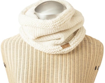 May include: Cream-colored knit infinity scarf. The thick, chunky knit scarf is displayed on a mannequin. A small, rectangular brown tag is sewn on the front. The scarf is made of a soft, warm material, perfect for cold weather.