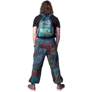 May include: A person wearing blue and green patchwork trousers with a blue and green backpack featuring a mushroom design.