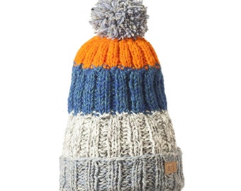 May include: A striped knit beanie with a pom pom on top. The beanie is orange, blue, and gray. The beanie has a small brown label with the word "art" on it.