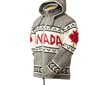 May include: A gray hooded zip-up sweater with the word "CANADA" in red letters across the chest. The sweater features a red maple leaf on the right sleeve and black and white geometric patterns. The hood is lined with gray fabric.