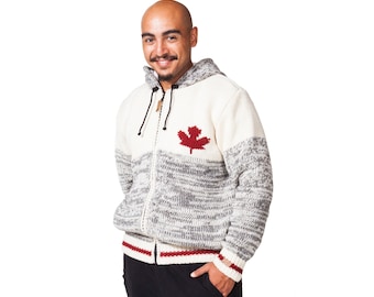 May include: A hooded zip-up sweater with a red maple leaf emblem on the chest. The sweater features a color-block design with cream, gray, and red accents. The sweater has a drawstring hood and ribbed cuffs.