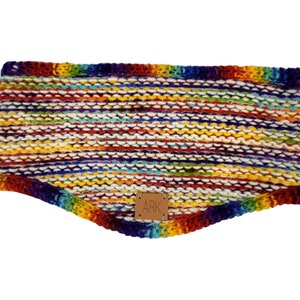 May include: A colorful, knitted headband in a rainbow of hues. The headband features a textured, horizontal stripe pattern with a leather tag that reads "ARK". The accessory is designed to keep the ears warm.
