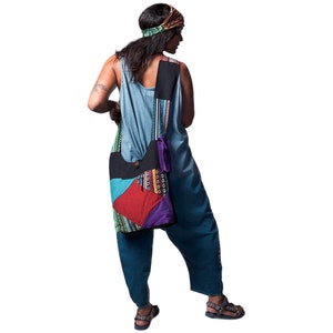 Peut inclure: Une femme portant un haut bleu et vert à motifs et un pantalon bleu avec un sac en patchwork coloré en bandoulière.
