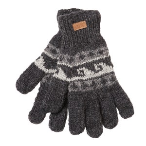 May include: Dark grey knitted gloves with a white and grey geometric pattern. A small brown leather tag is sewn on the cuff. These gloves are designed for warmth and comfort, ideal for cold weather.