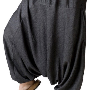 Peut inclure: Pantalon de harem en coton gris avec une taille à cordon et une coupe ample.